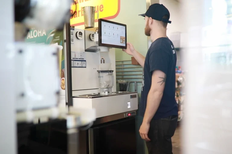 L&L Hawaiian Barbecue employee selects a drink option on the Botrista beverage system touchscreen.